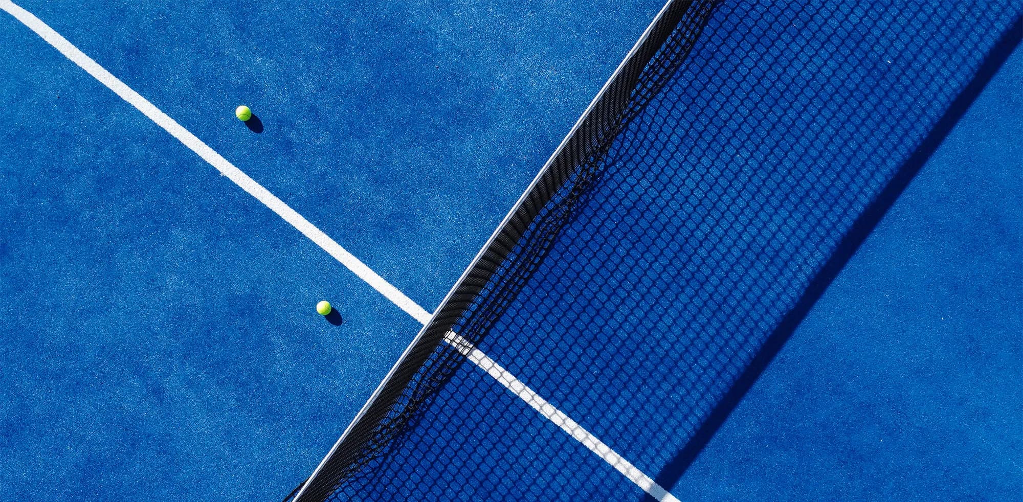 Padel kortunda raketiyle dinlenen bir oyuncu